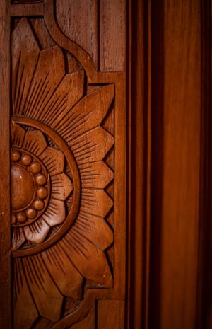Detailed floral carving on a wooden surface, highlighting exquisite artisan techniques in home decor.