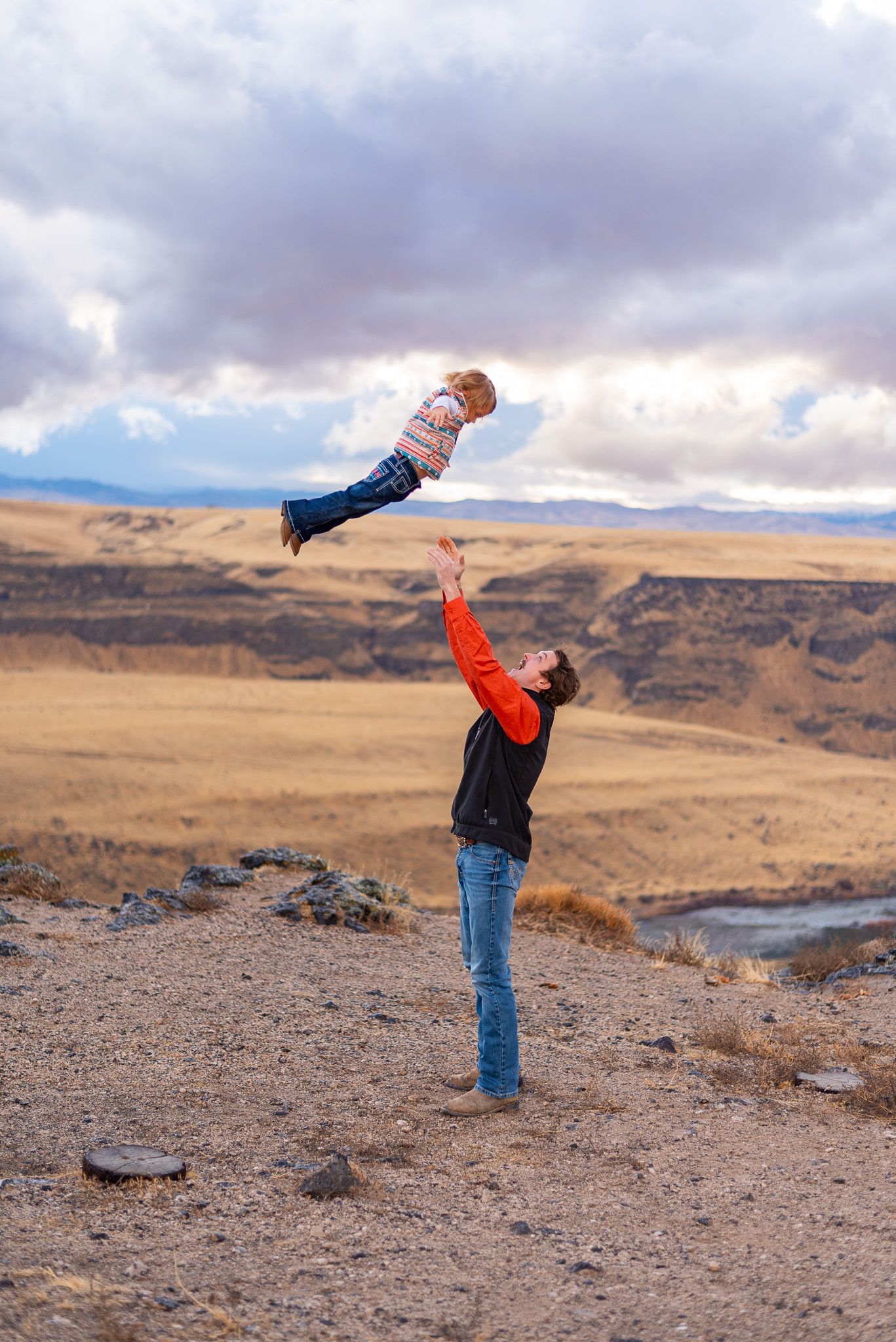 Romantic couple spinning and dancing together on a scenic desert cliffside overlook.