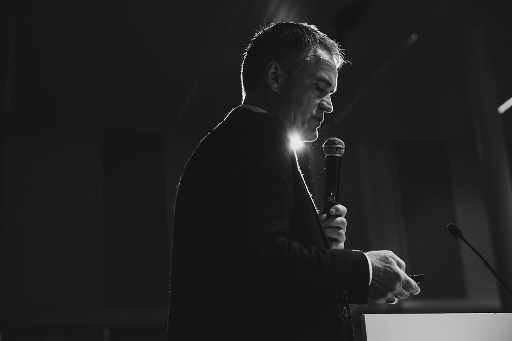 Dramatic black and white stage performance with spotlight effects.
