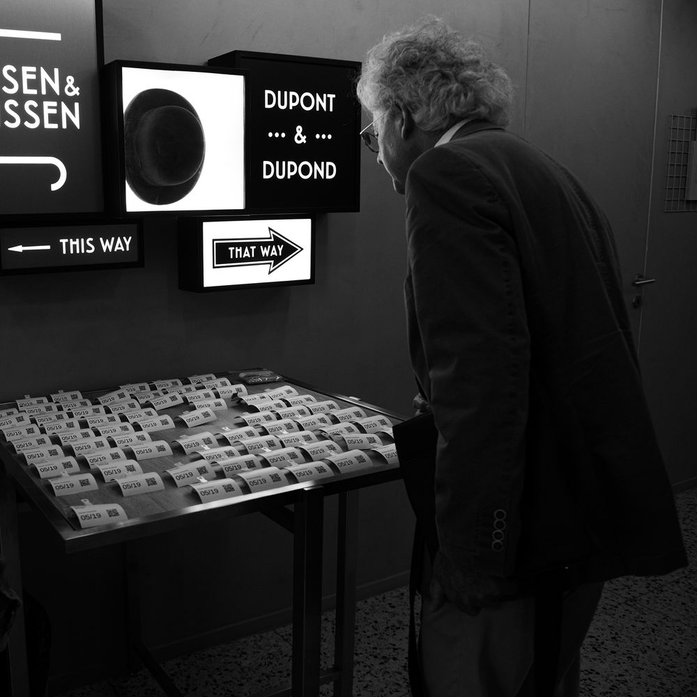 Exhibition display with illuminated signage and wayfinding elements in dark space.