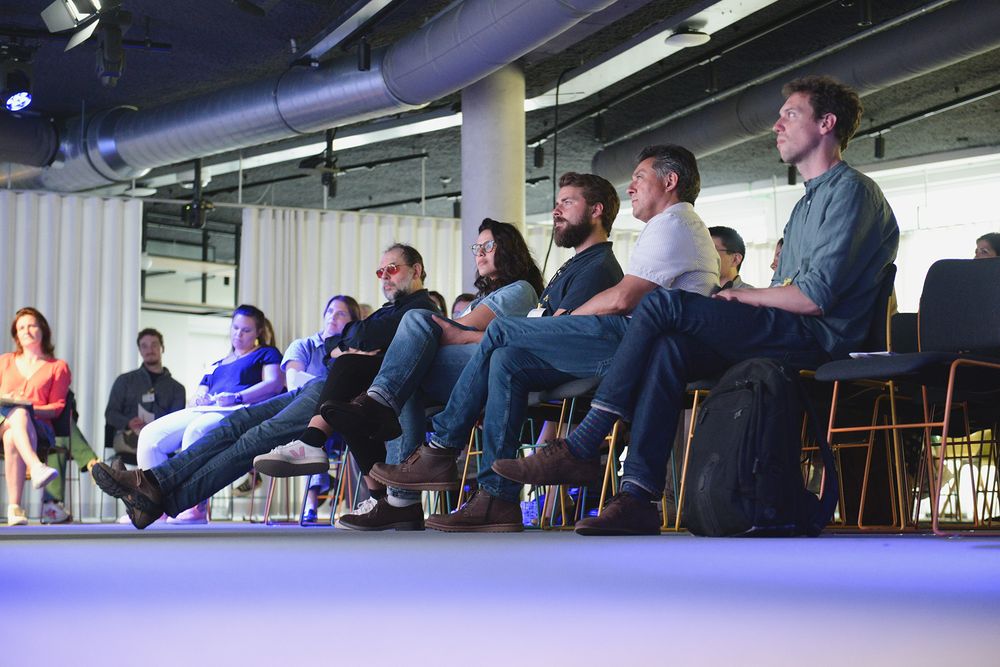 Conference attendees seated in rows during presentation session.