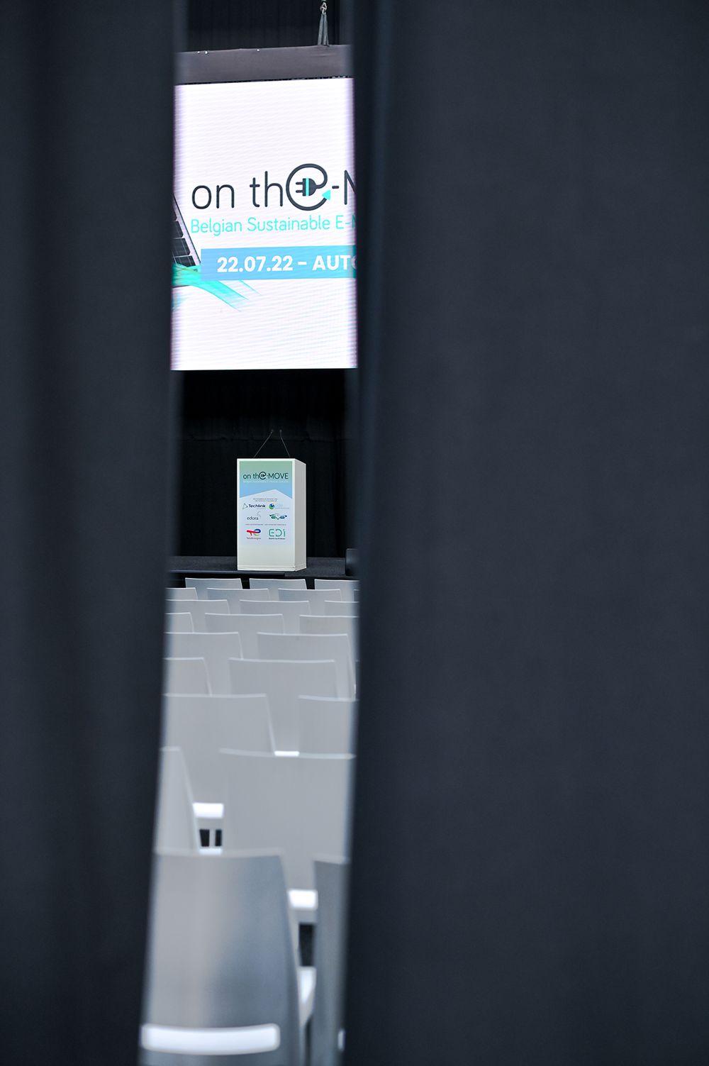 Corporate signage and display screens mounted on dark walls.