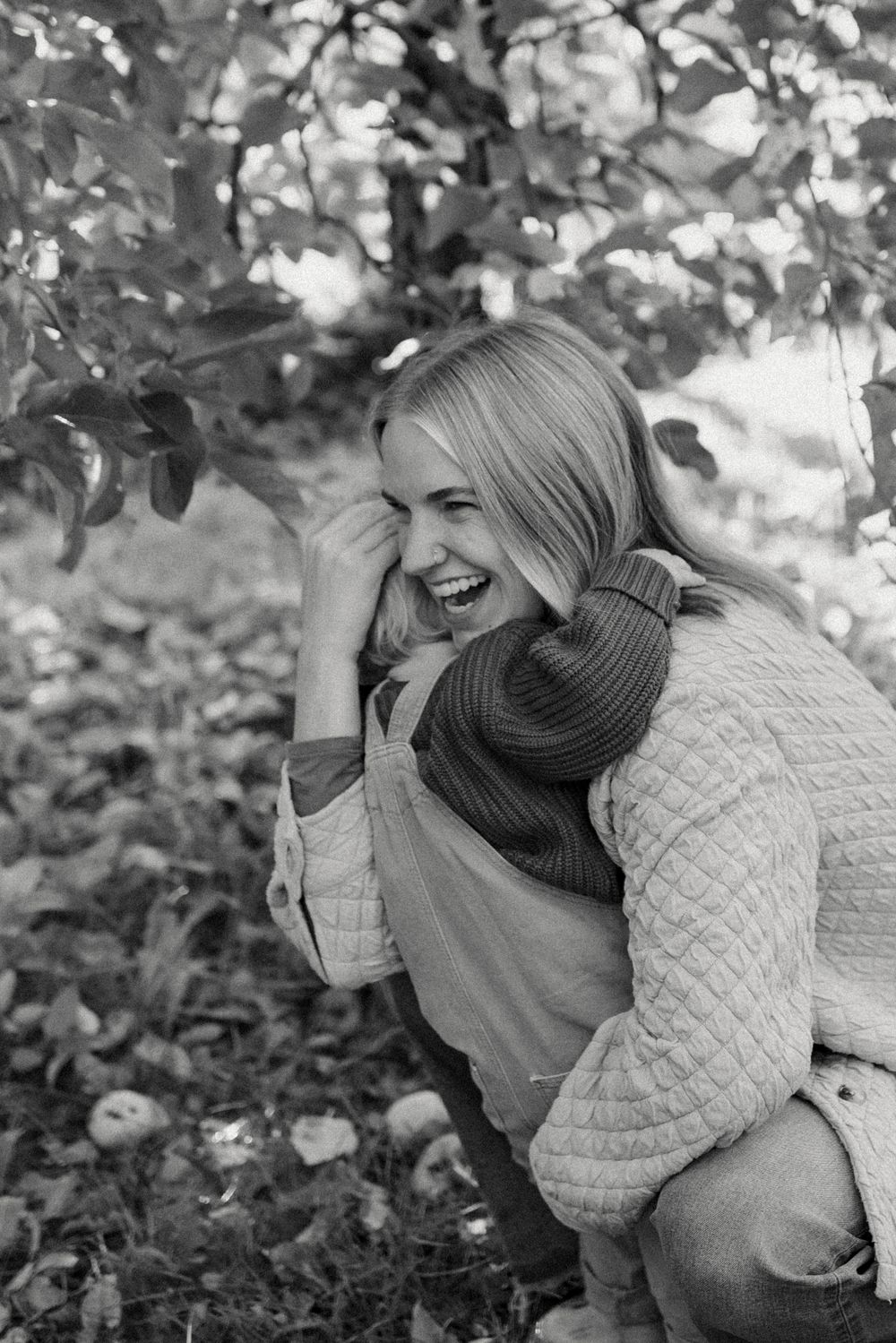 A candid moment of joy and laughter while apple picking on an autumn day.
