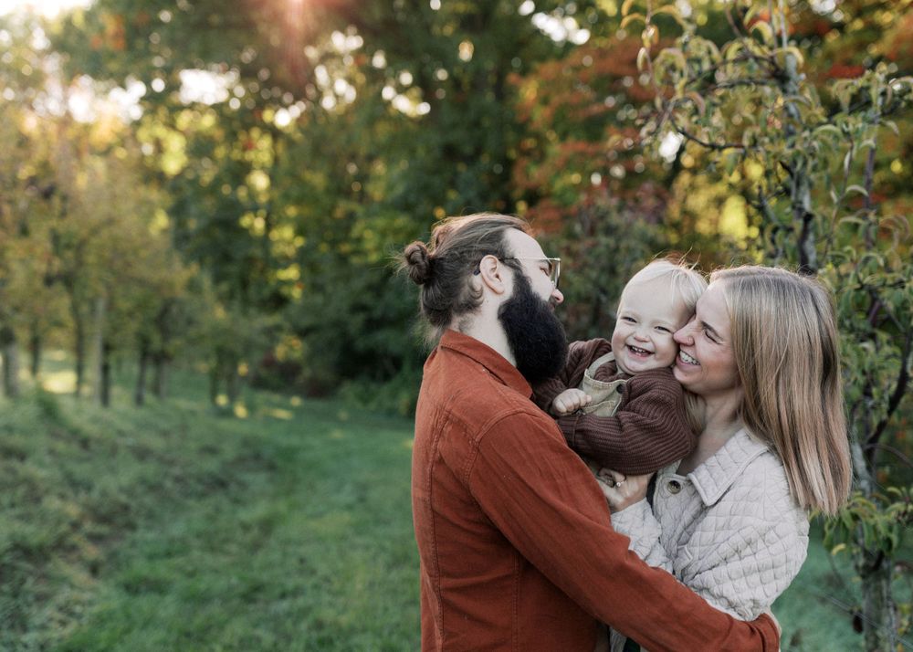 An intimate family embrace captured outdoors with golden autumn light.