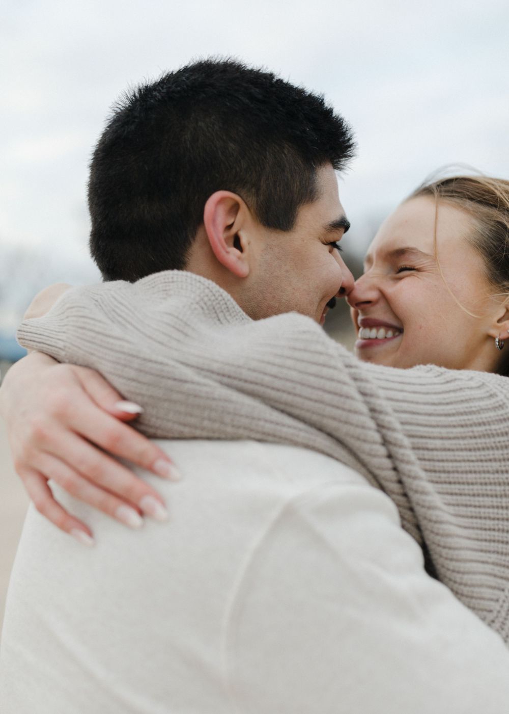 An intimate close-up of a couple sharing a warm embrace on the beach.