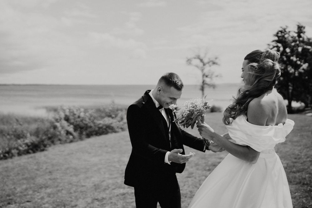 Black and white wedding photos showing romantic moments on a hillside.