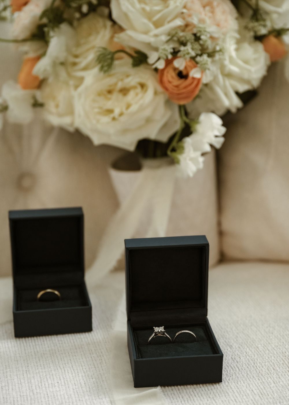 Multiple black ring boxes arranged with white floral decorations in the background.