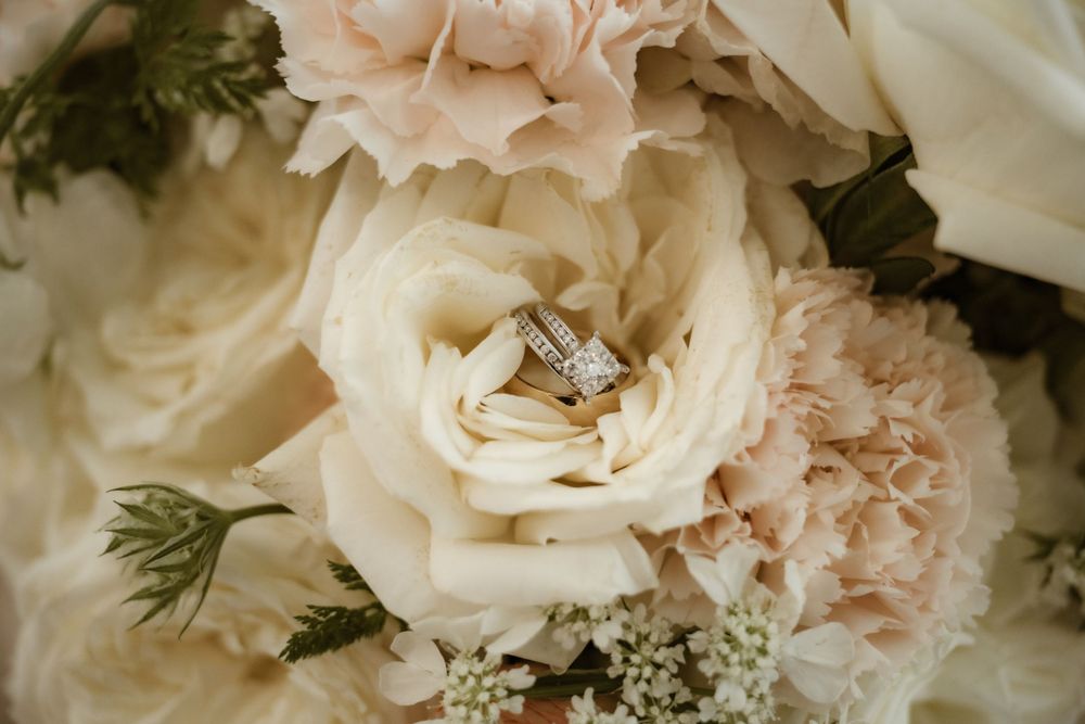 Delicate pink and white roses arranged in an elegant wedding bouquet with soft greenery accents.