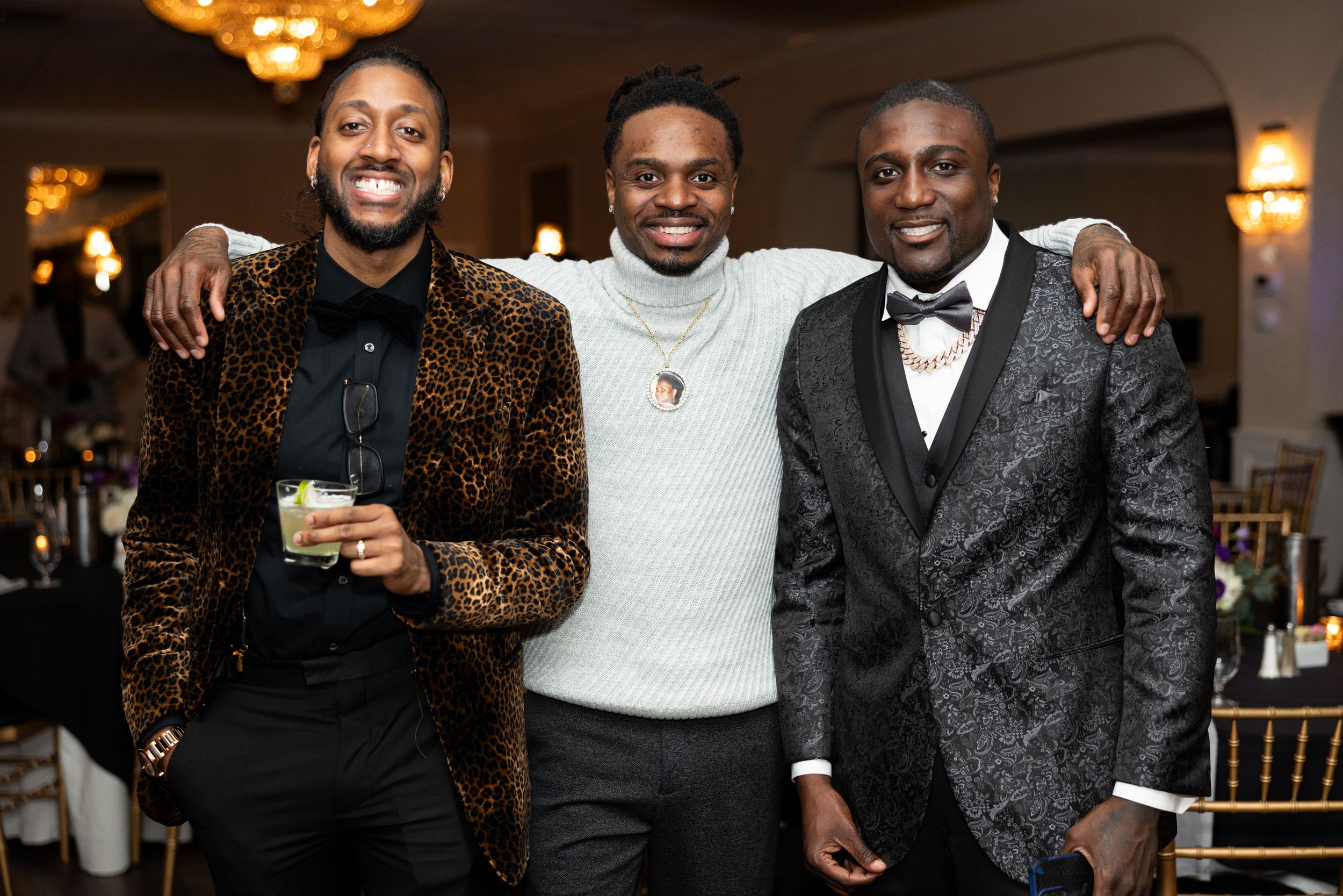 Three companions share a joyful moment together at a formal celebration.