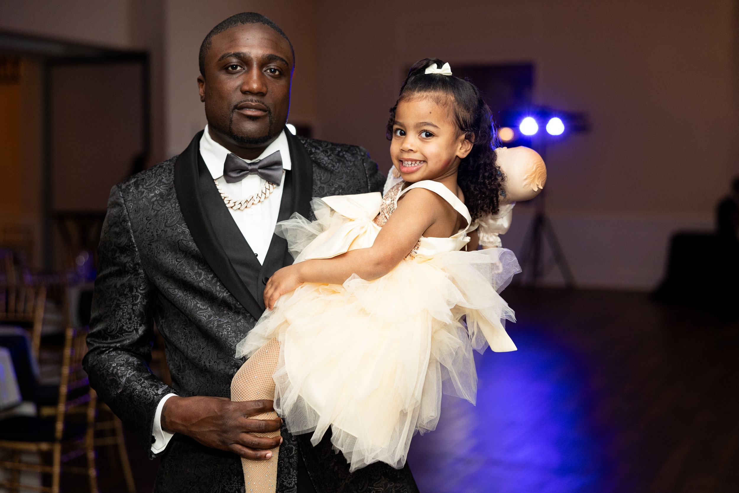 Tender moment captured during a formal celebration featuring elegant attire.