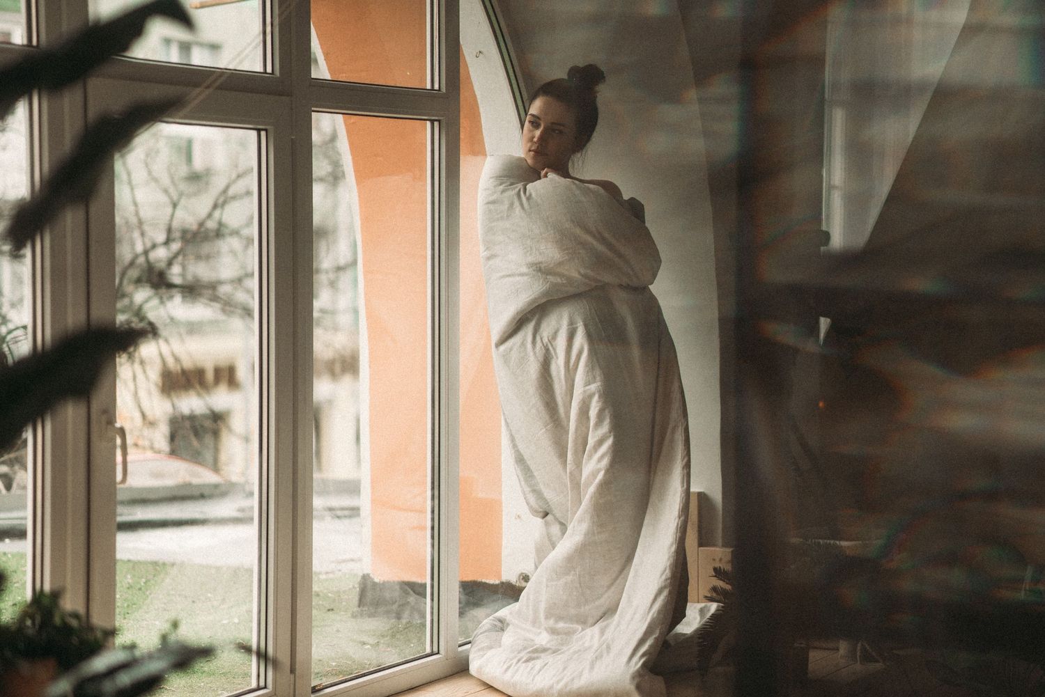 Artistic window portrait series with soft natural lighting and shadow play.