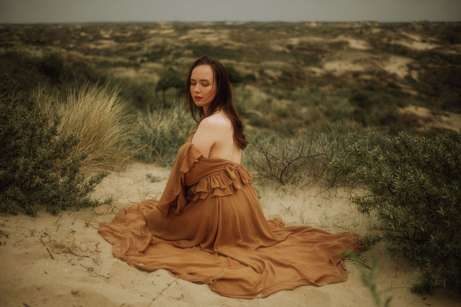 Woman in the dunes during an intimate outdoor boudoir photoshoot – romantic portrait with bare back