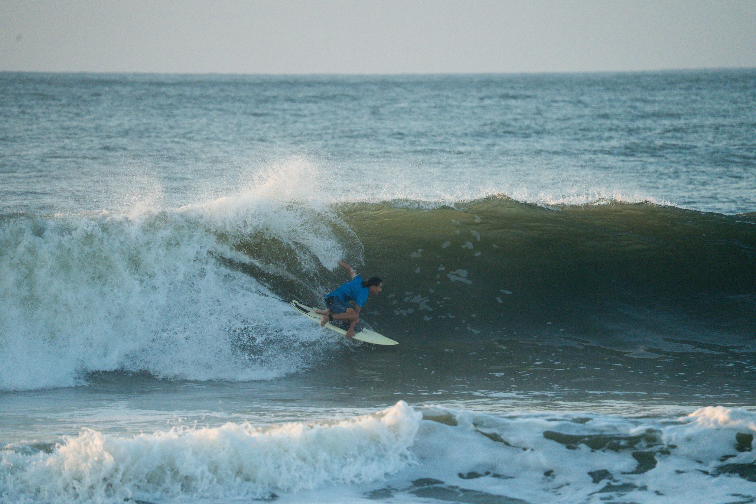 Surfer navigates through breaking ocean waves during intense surfing session.