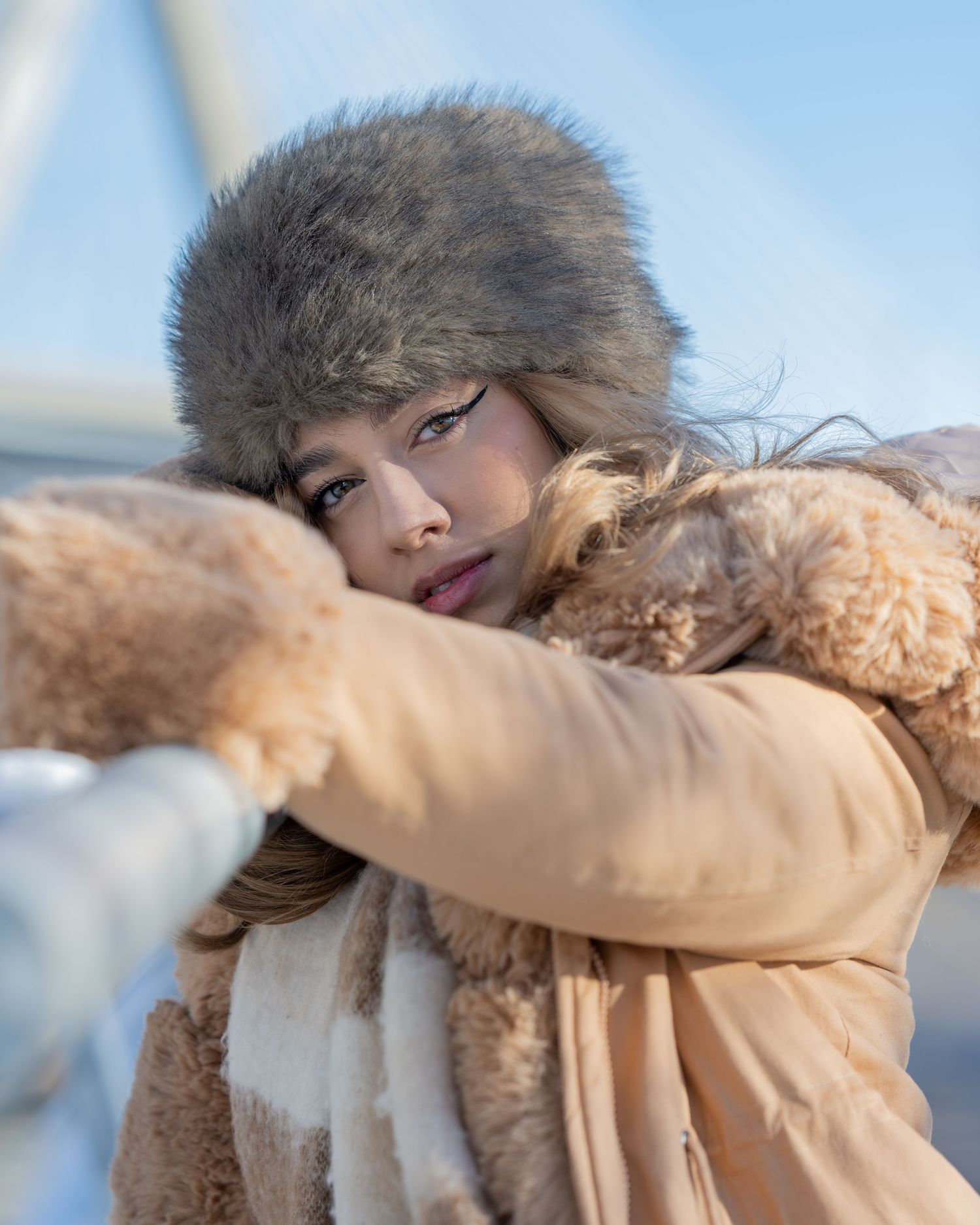 Woman poses in Boston in the winter. She looks into the camera confidently and powerfully.