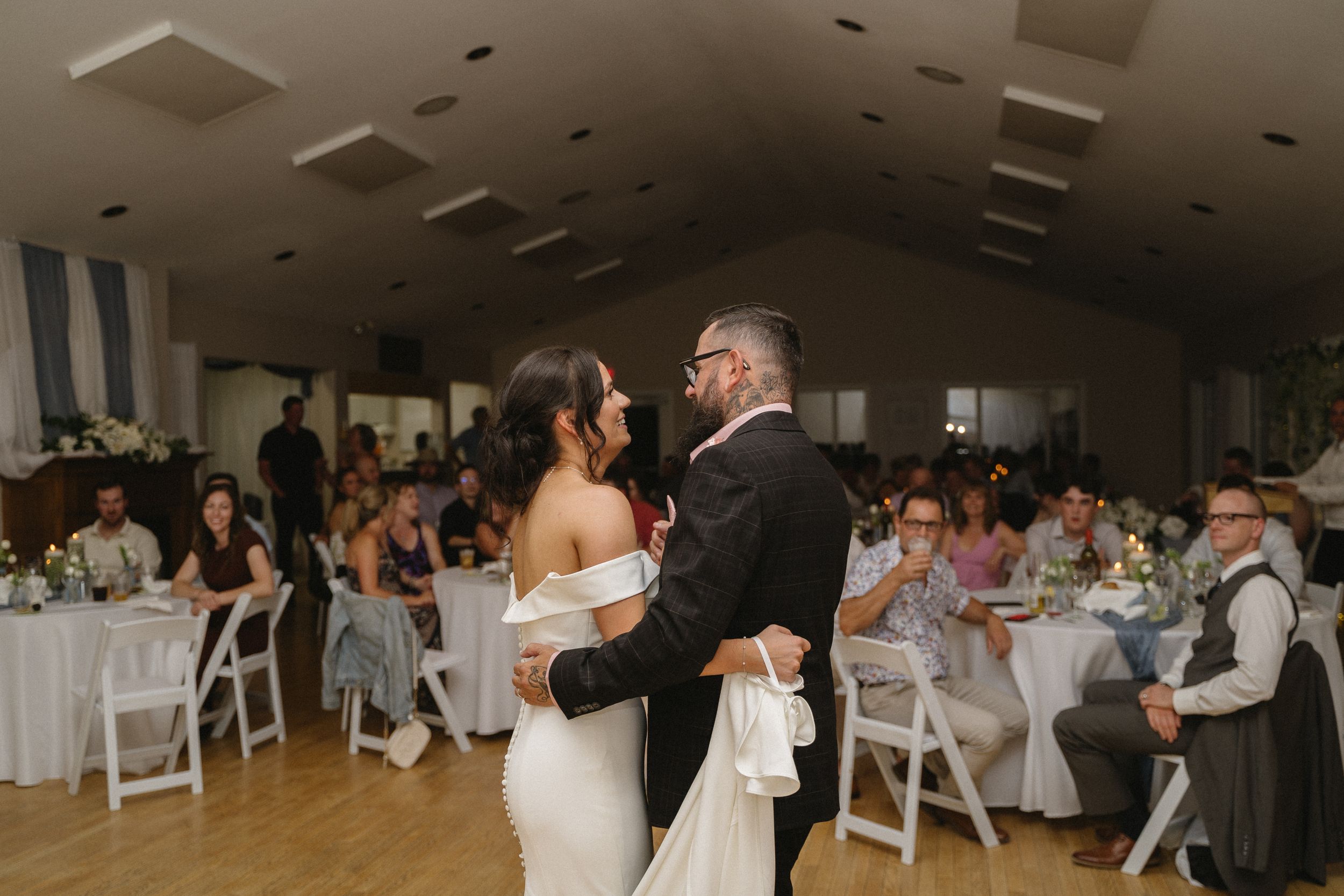 A father daughter dance surrounded by guests in a beautifully decorated reception hall.