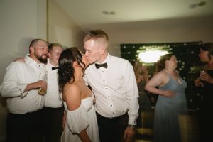 A joyous celebration on the dance floor at a wedding reception with guests in formal attire.