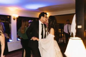 Couple shares their first dance at wedding reception with blue lighting and decor.