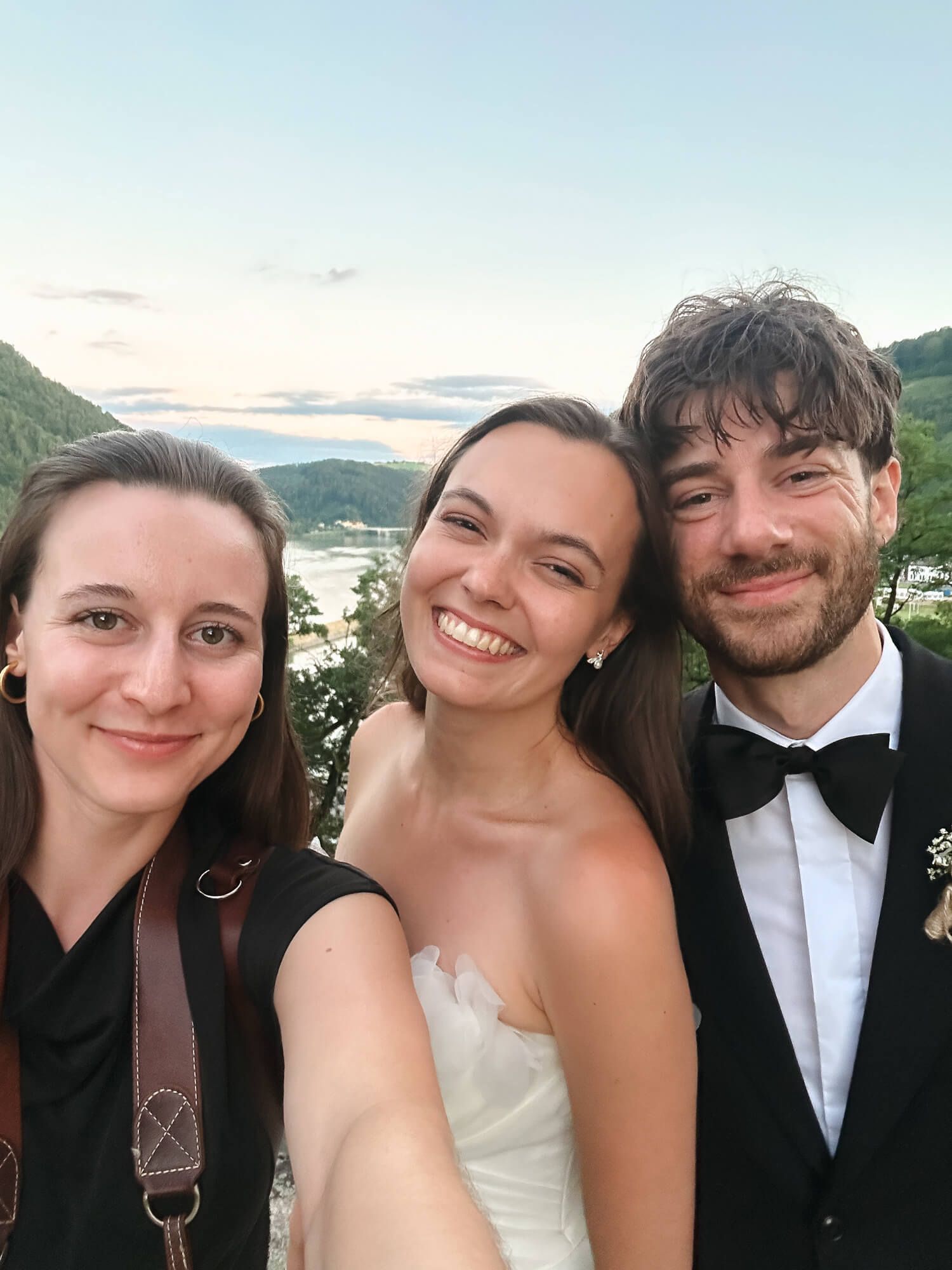A selfie of a photographer with a freshly married couple.