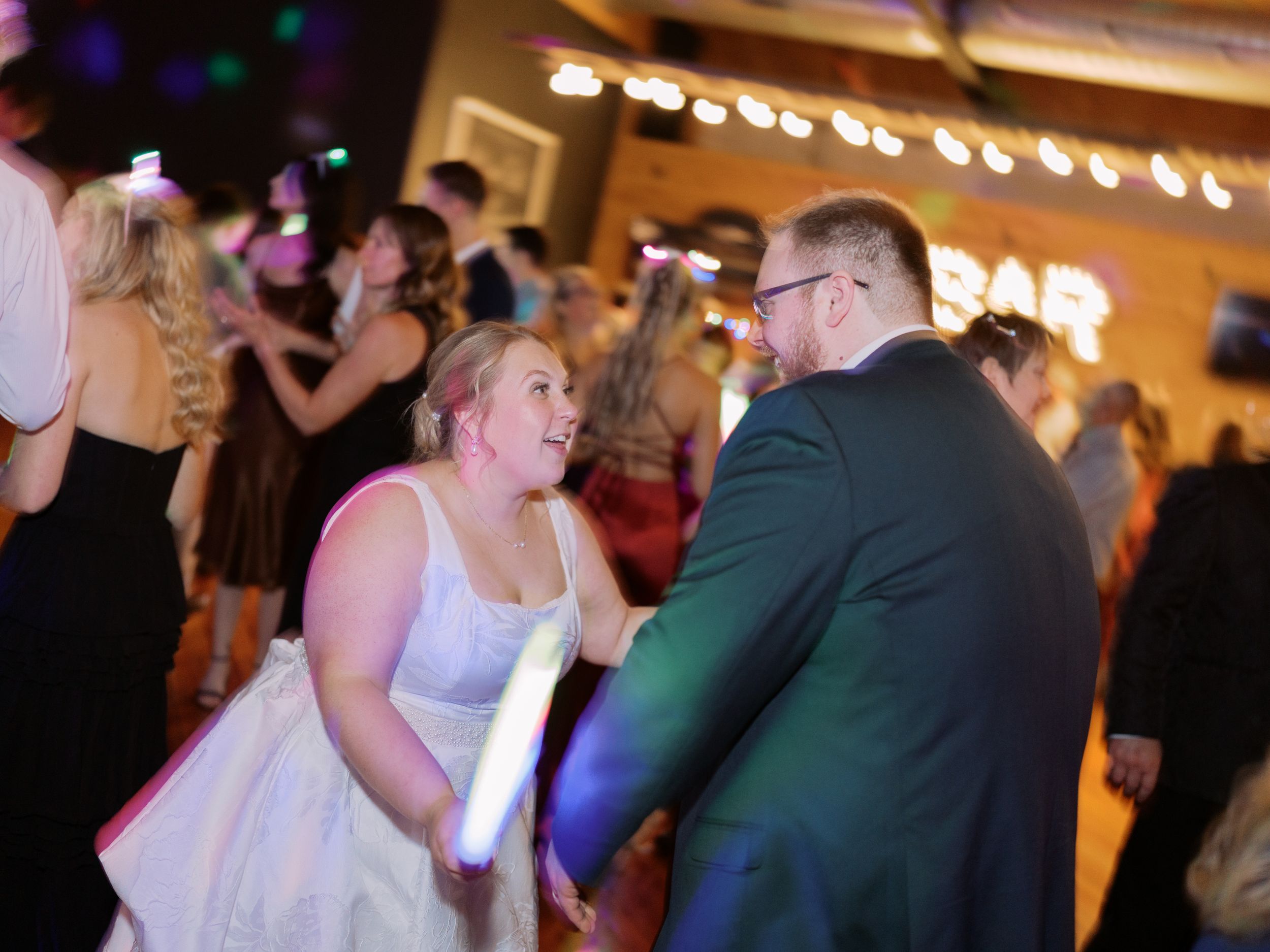 Couples dancing together at a wedding reception with warm lighting and festive atmosphere.