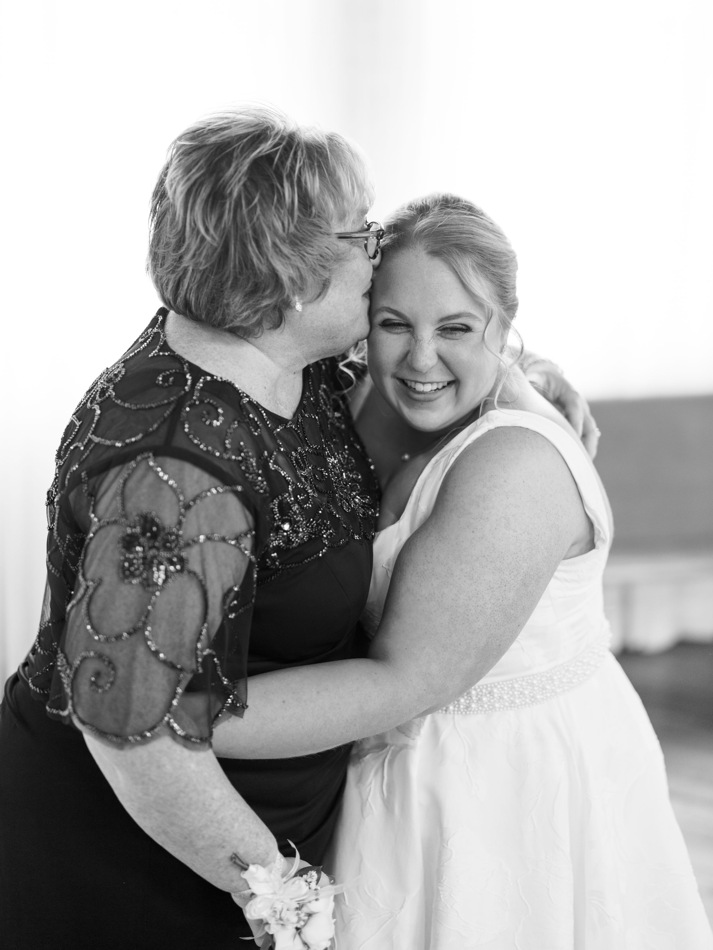 A black and white photo series shows a tender moment between two people embracing in formal attire.