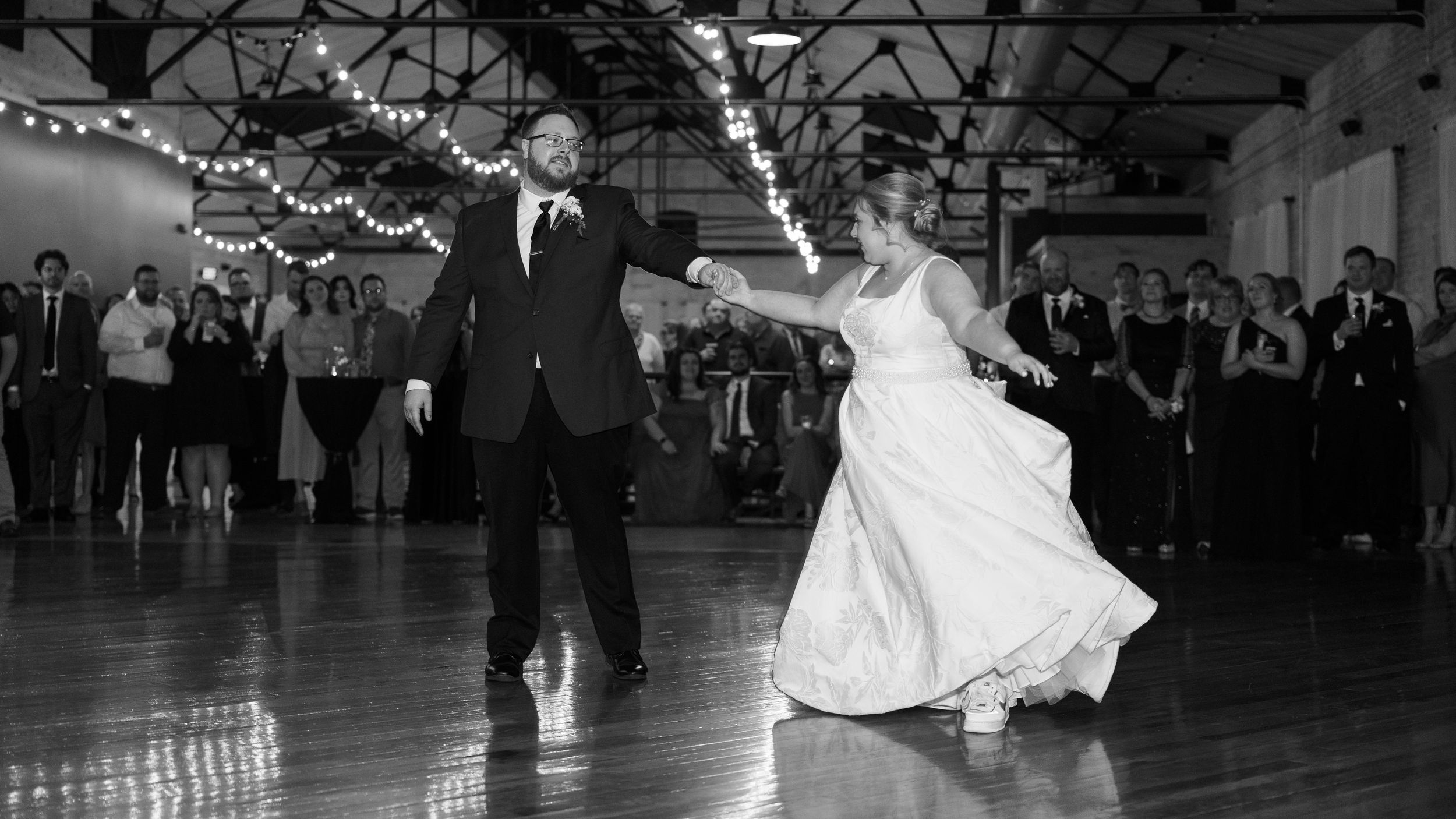 Black and white photograph of couples dancing in formal attire at an elegant ballroom dance competition.
