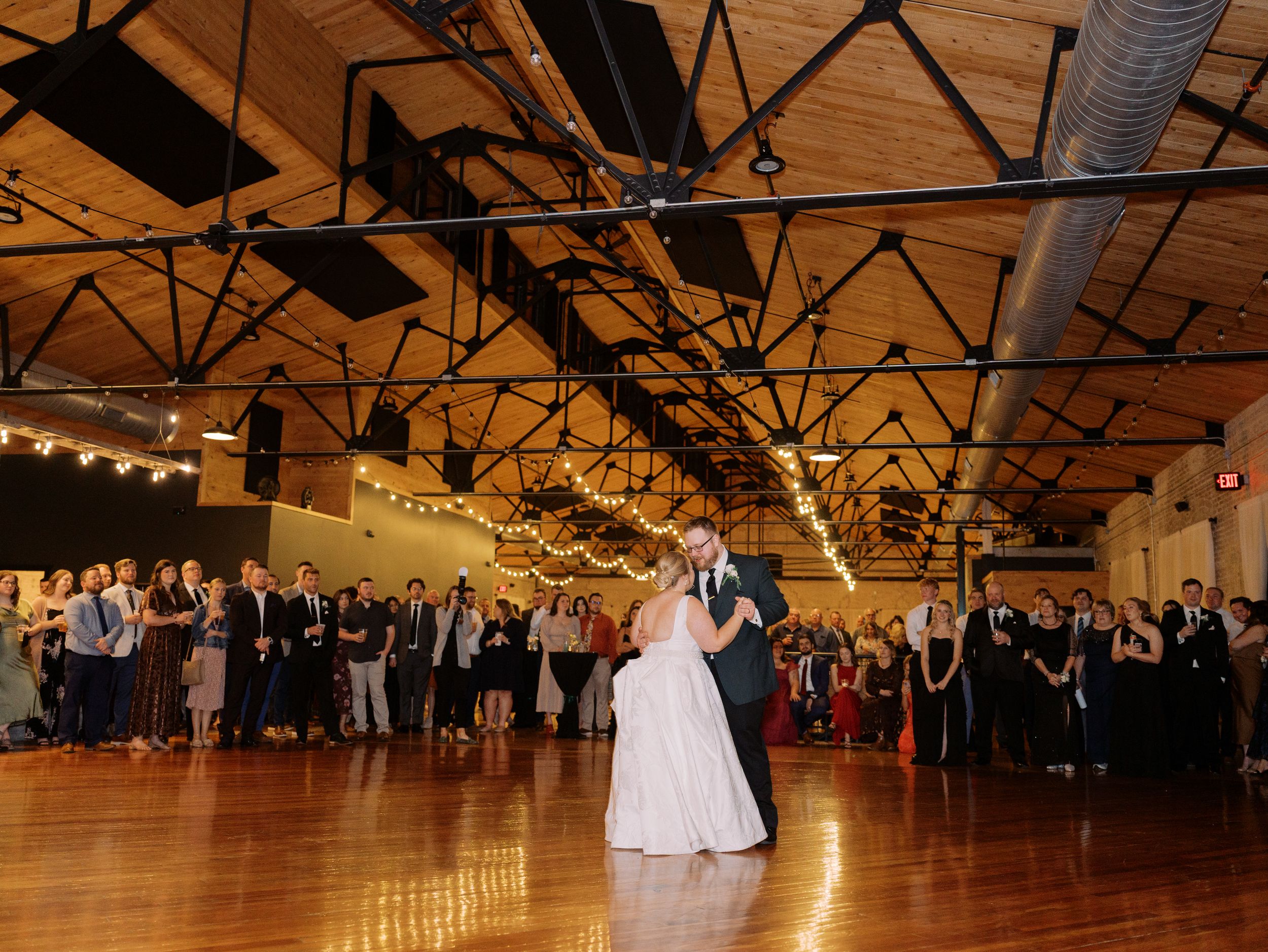 A sequence of panoramic shots showing a couple dancing at their wedding reception in a rustic wooden venue.