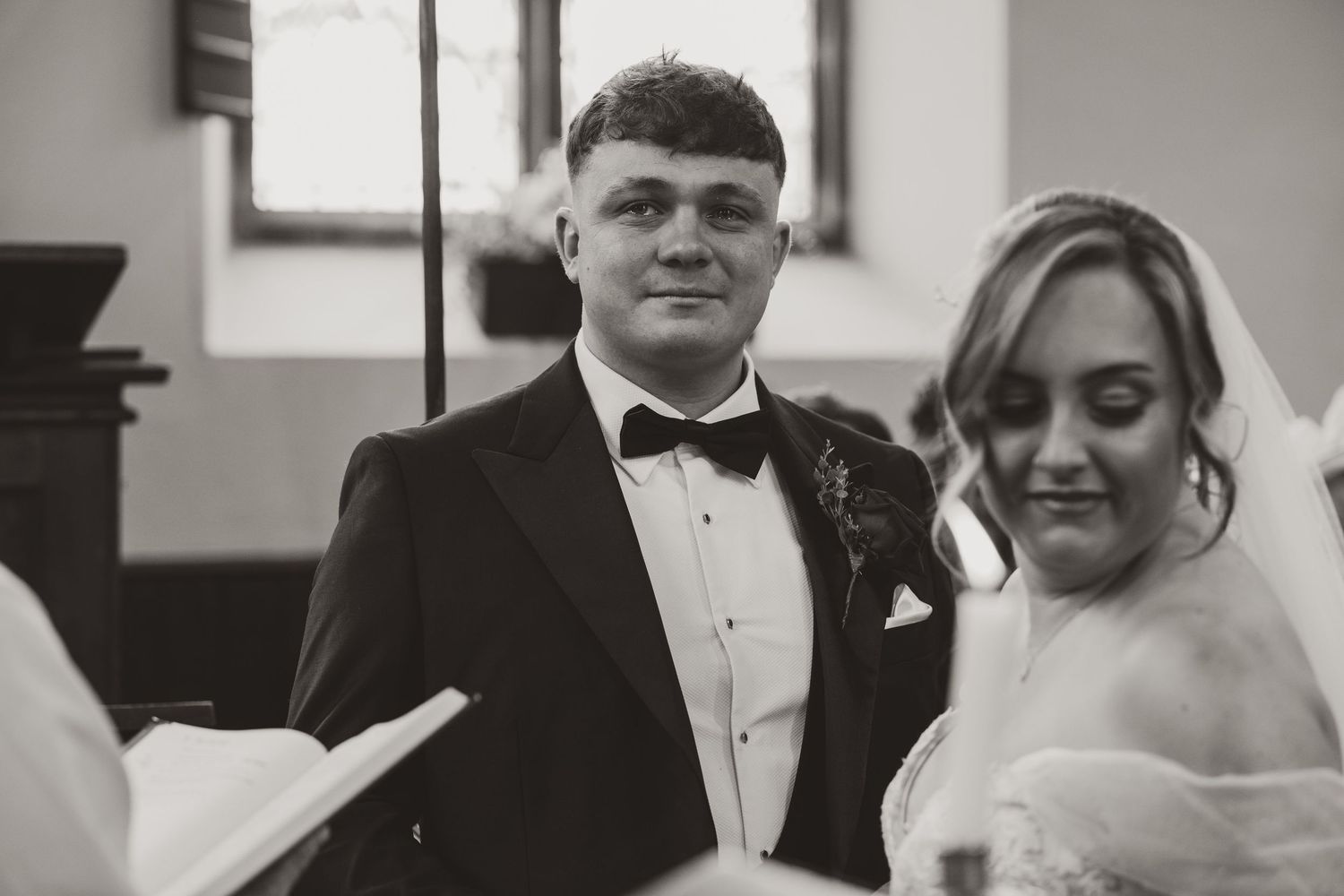 A black and white photo strip showing a couple in formal wedding attire in four different poses.
