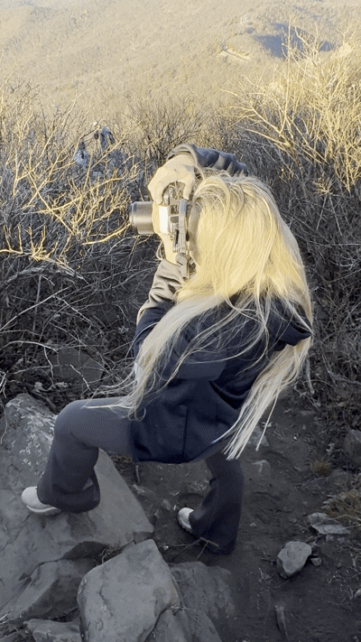 A sequence of photos showing someone in black clothing lying down on rocks while taking a photograph.