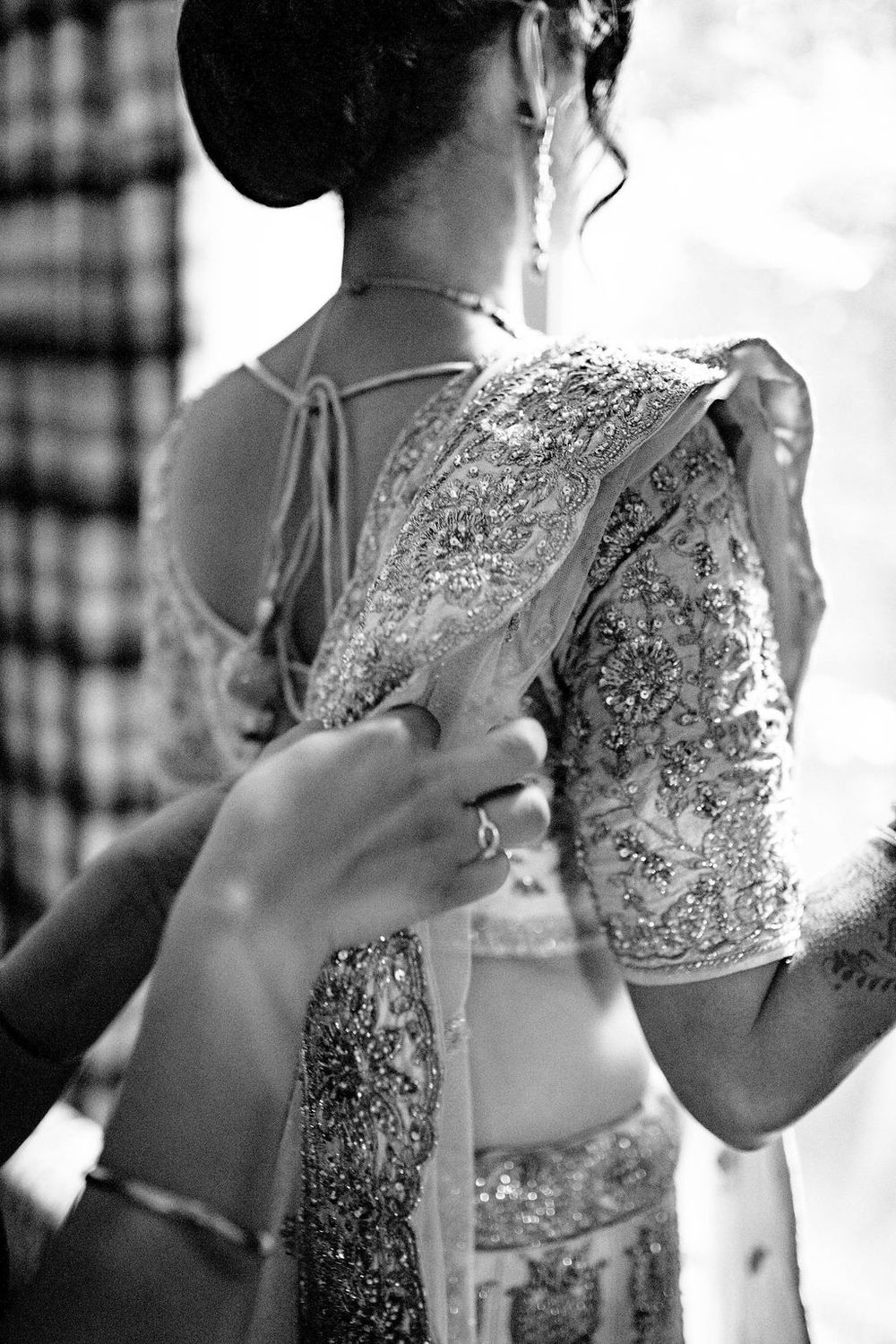 Close-up shots of intricate white lace and beading details on a wedding dress during preparation.