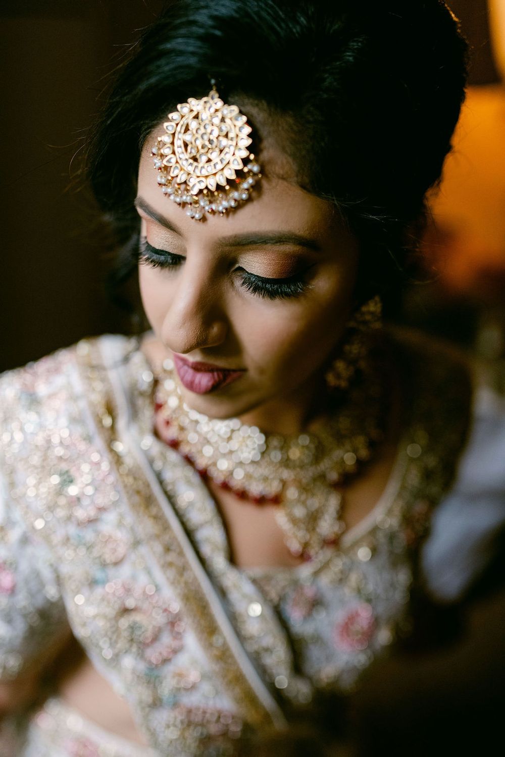 Close-up details of bridal jewelry and embellished traditional Indian wedding attire.