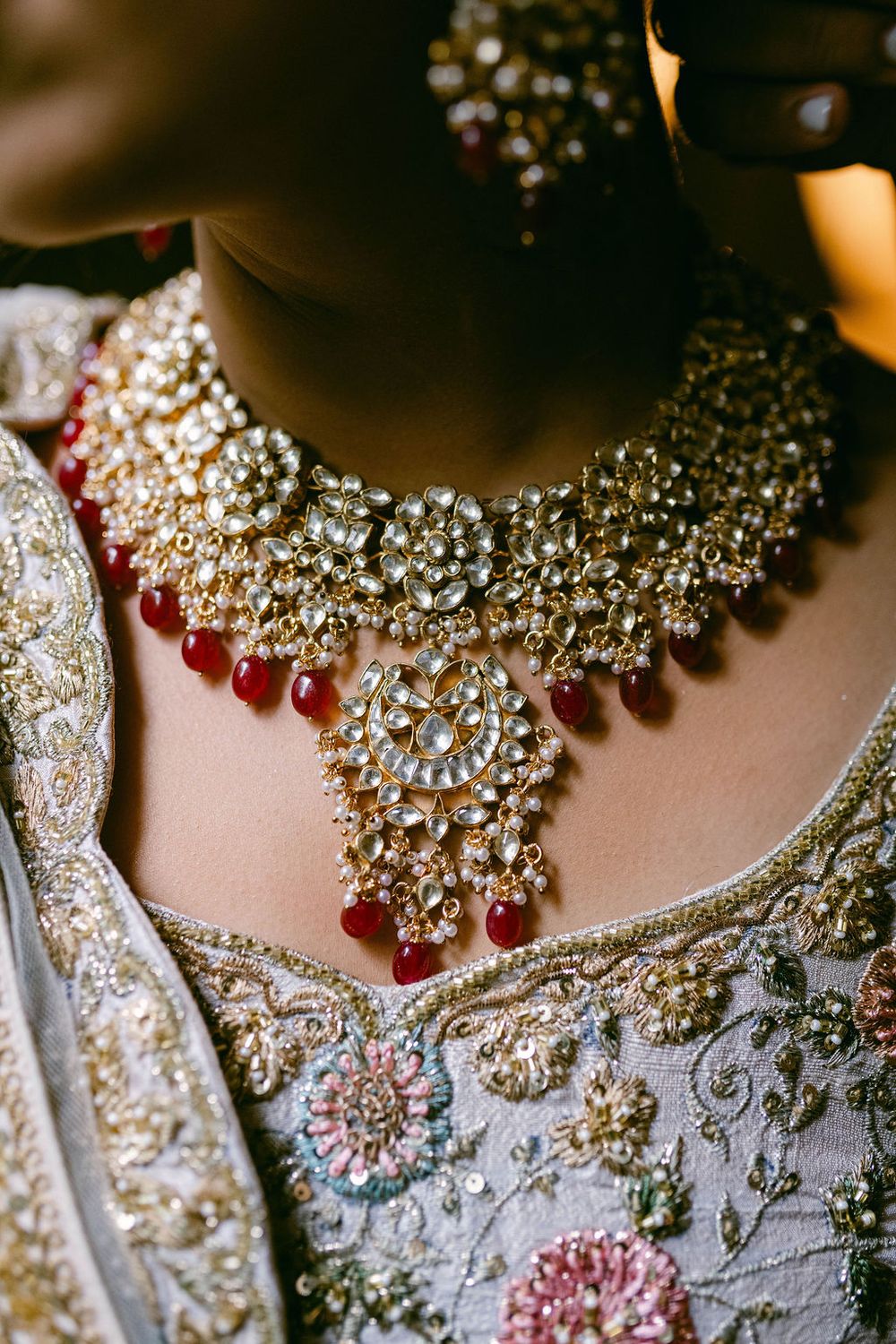 Ornate gold and crystal wedding necklace with intricate beadwork on white fabric.