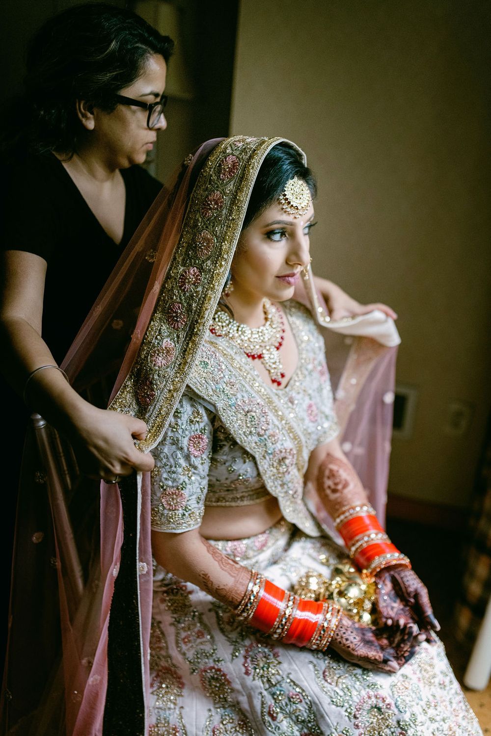 Close-up shots of a bride in traditional Indian lehenga with intricate embroidery and red bridal bangles.