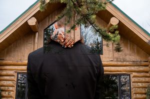 Rustic log cabin wedding venue exterior with decorative chalkboard signs.