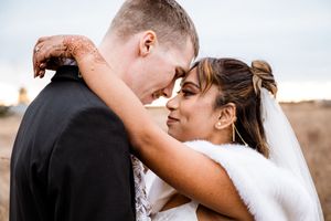 Romantic outdoor wedding photoshoot with a couple sharing intimate moments against a natural backdrop.