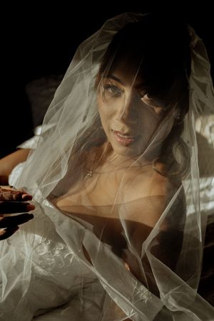 Artistic bridal portrait through sheer white veil creating a romantic, ethereal effect.