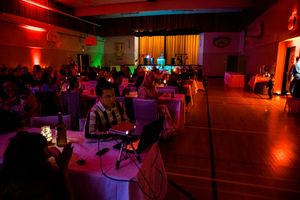 Nightclub interior with red and purple mood lighting illuminating a dance floor and seating areas.