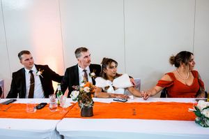 People sitting at a long conference table during a business meeting in a white-walled office space.