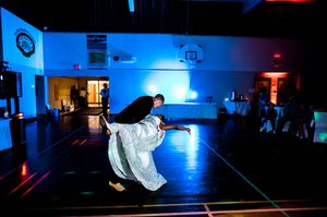 Wedding reception venue lit with dramatic blue uplighting creating a moody atmosphere.