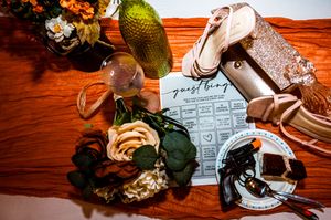 Wedding reception table details with rustic decor and place settings on wooden surface.