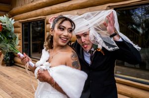 A couple shares a romantic dance during their wedding celebration at a rustic wooden lodge venue.