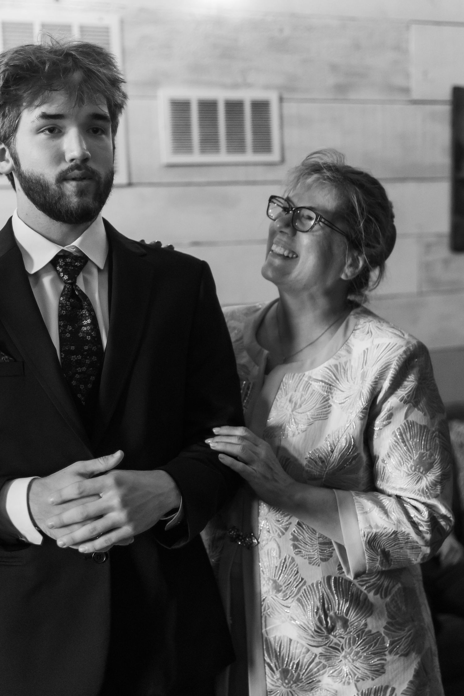 A black and white photo series showing a romantic couple in formal attire embracing and sharing intimate moments.