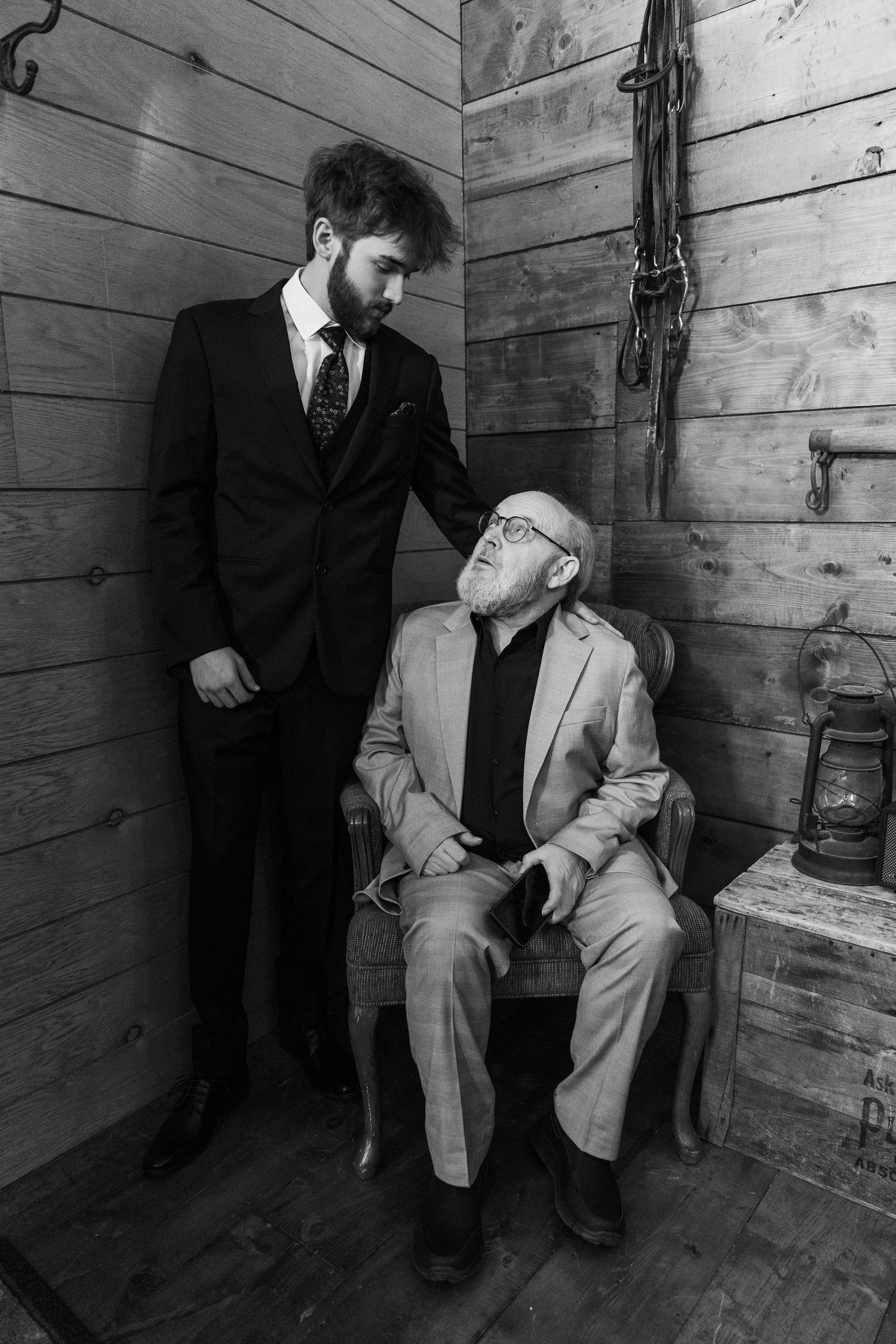Black and white photo sequence showing a figure in a suit sitting down in a rustic wooden room.