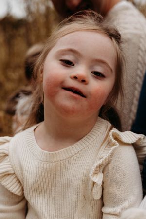 A series of warm-toned photos showing expressions of joy in a cream colored sweater.