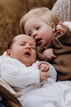 Candid close-up shots in soft lighting showing tender moments in white and brown clothing.