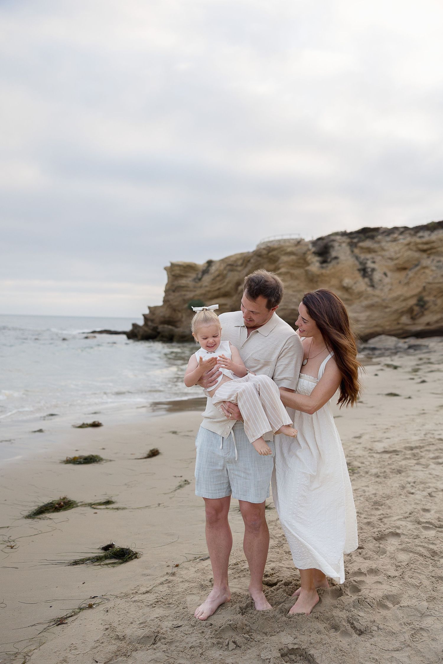 Crystal Cove beach family session with parents cuddling their child