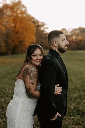 Intimate wedding couple shares tender moments against vibrant fall colors in an outdoor setting.
