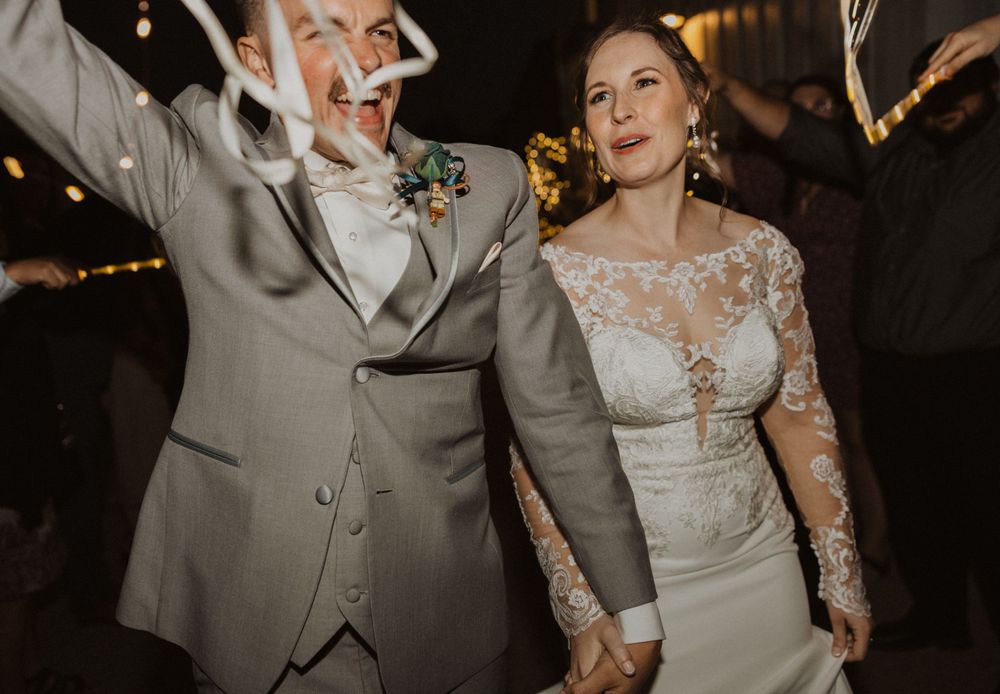 Couple shares joyful moment during their sparkler exit celebration.
