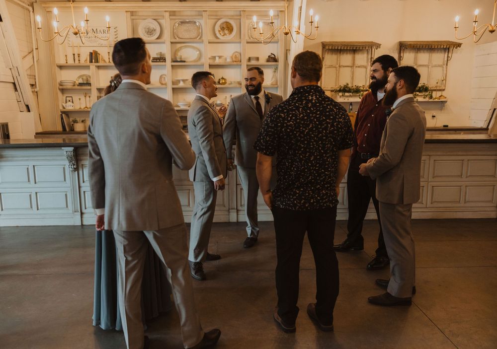 Wedding reception venue with classic white decor and guests mingling in formal attire.