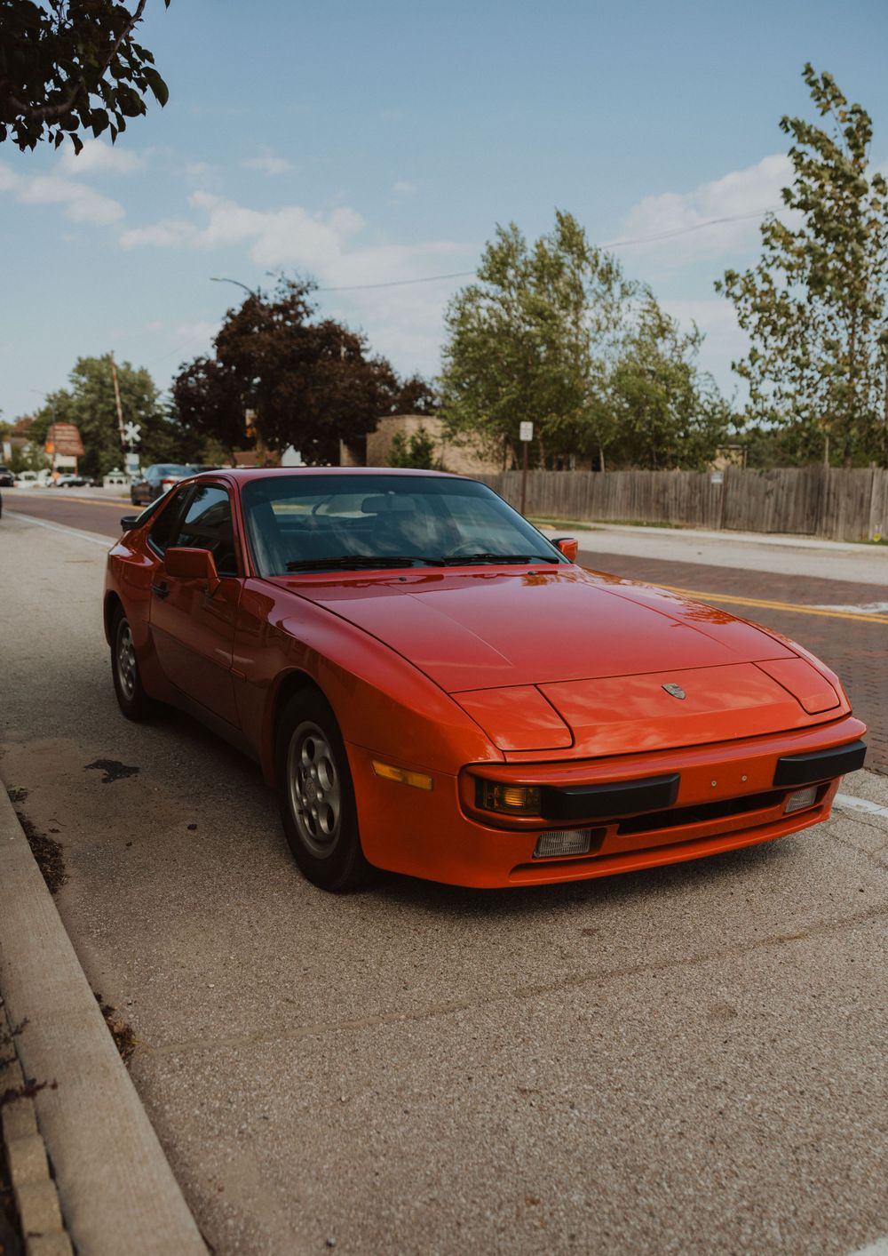 Classic red Ferrari sports car parked on street during wedding day.