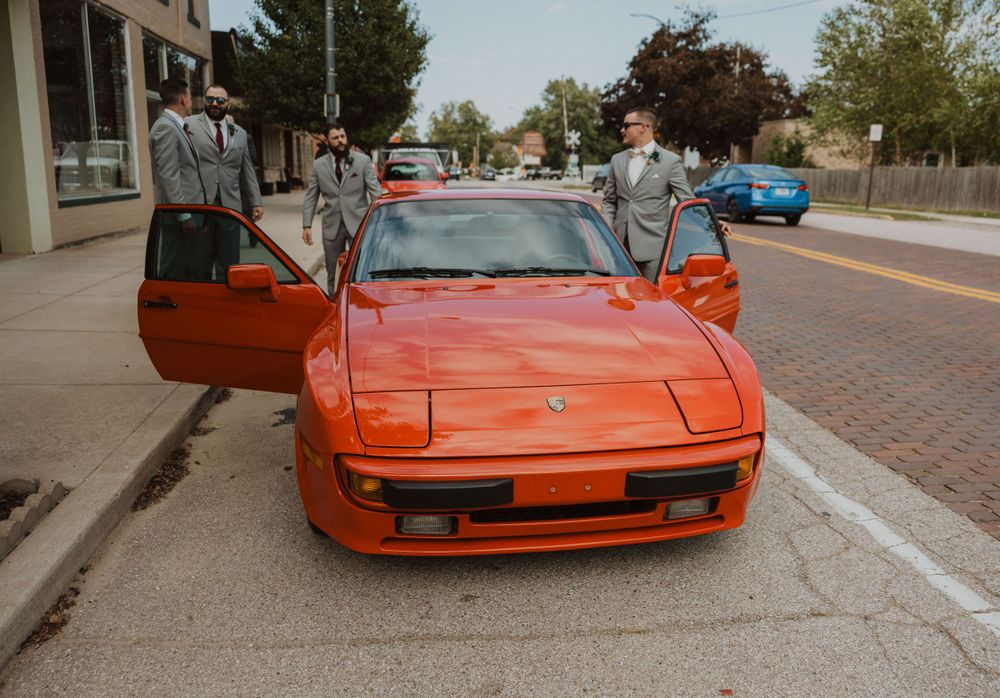 Vintage orange Ferrari sports car showcased in parking lot.
